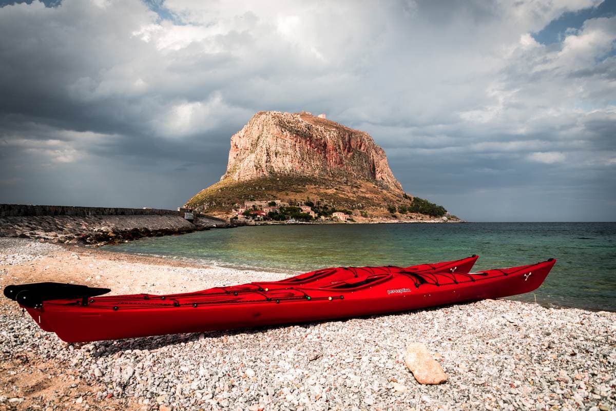 Rote Kajaks am Strand bereit für ein Seekajak-Abenteuer in Monemvasia