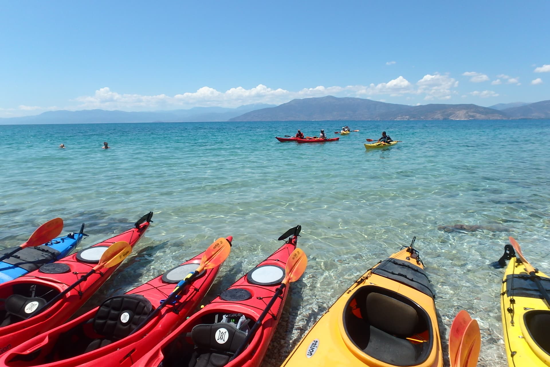 Seekajaks in einer Reihe an einem unberührten Strand während einer familienfreundlichen Seekajak-Tour in Nafplio