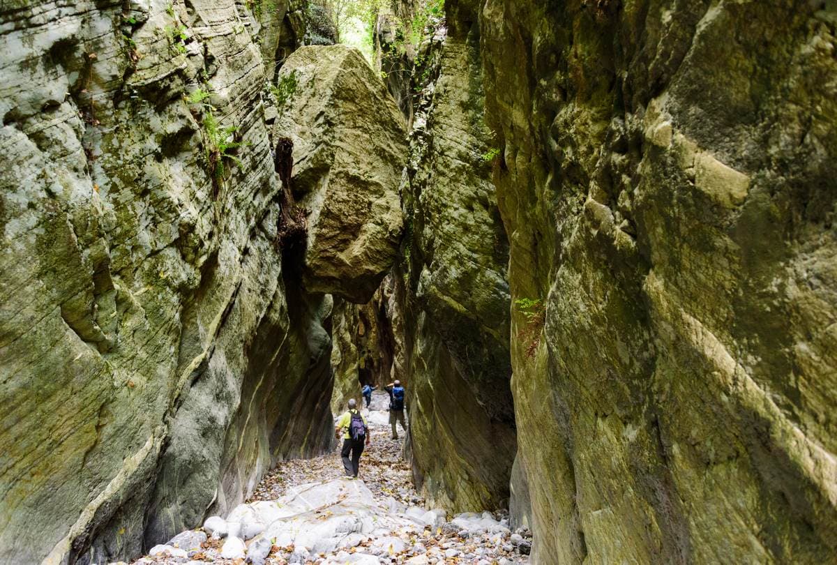 Geführte Wanderer im tiefen Kalkstein-Canyon der Ridomo-Schlucht auf der Halbinsel Mani