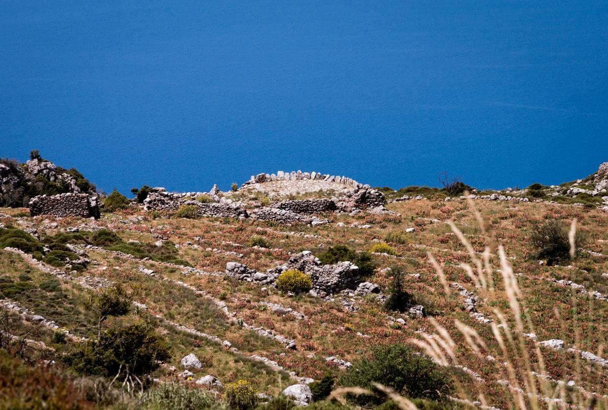 Remains of a dry-stone wall on a rocky hillside high above the deep blue Messinian Gulf near Kalamata
