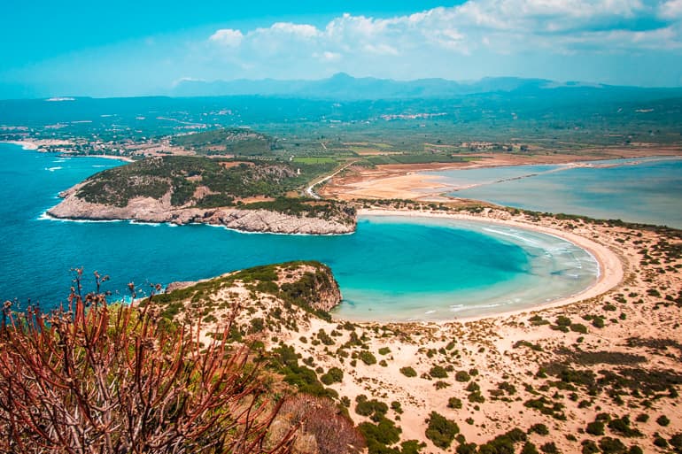 Aerial view of Voidokilia's omega-shaped beach and turquoise lagoon near Pylos