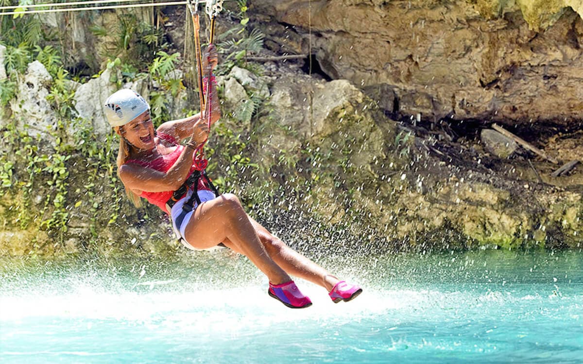 Frau auf der Zipline während der Canyoning-Tour an den Polylimnio-Wasserfällen