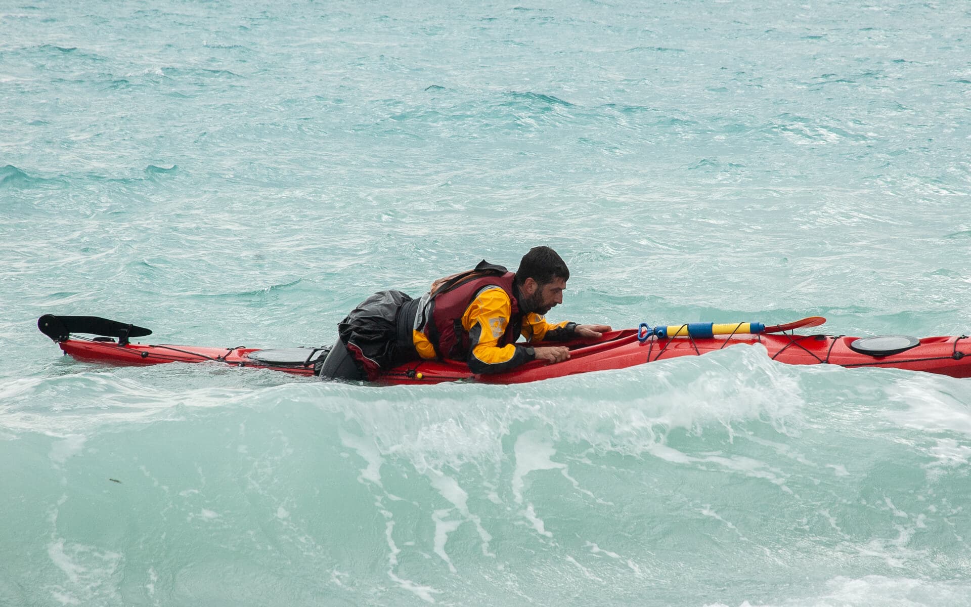 Practical demonstration of a sea kayak self-rescue re-entry in the waves.