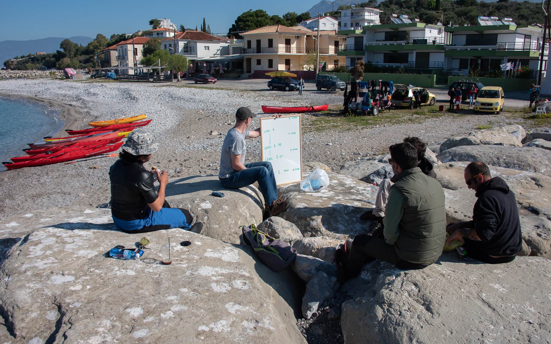 A group of students watching an instructor explain concepts on a whiteboard during Outdoor Sea Kayak Training.
