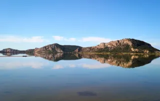 Explore Messinia A calm afternoon in Gialova lagoon with golden hour colors reflections and flamingos.