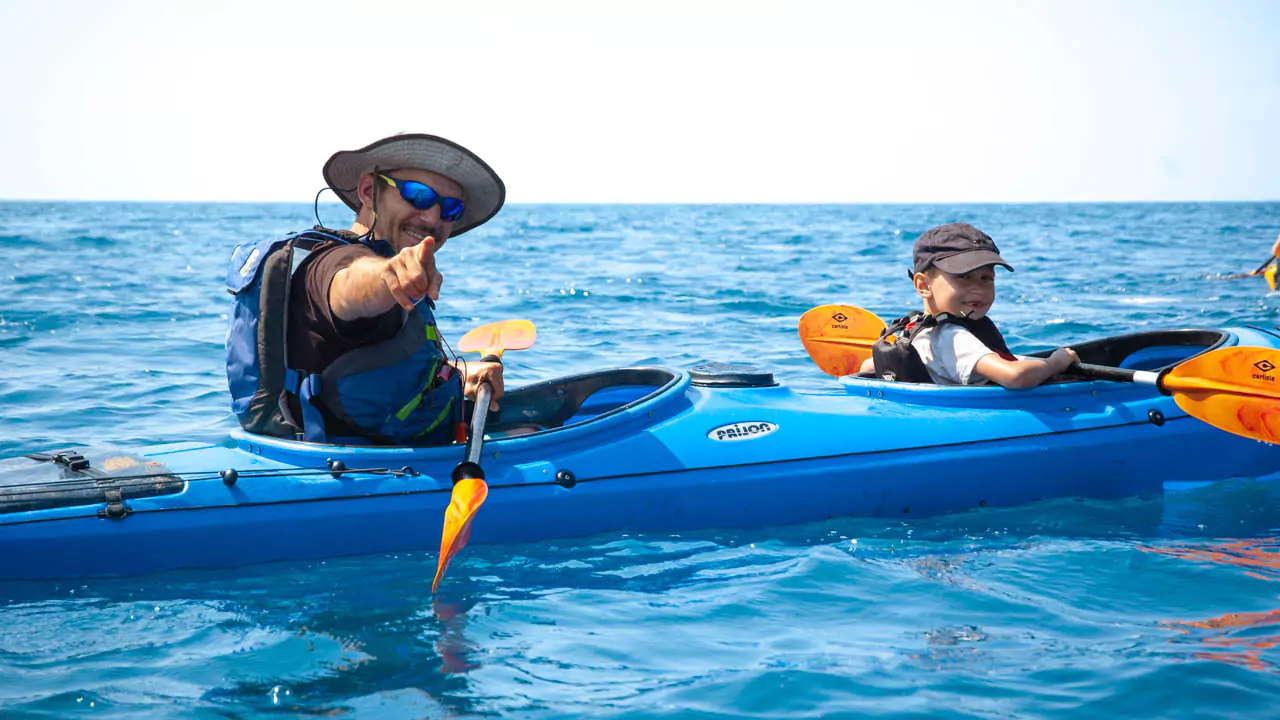 Explore Messinia-A boy and his dad in a Sea Kayak smiling at Navarino