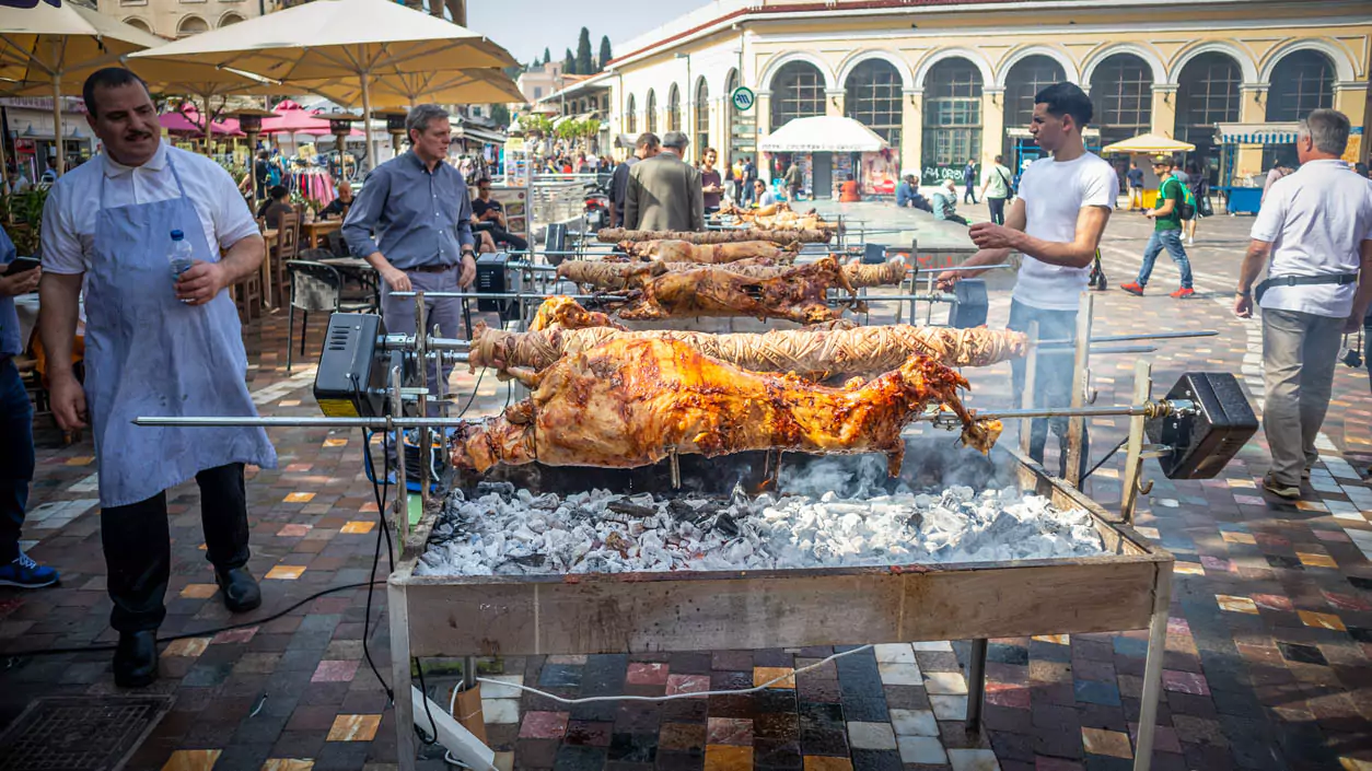 Explore Messinia-A long table adorned with roasted lamb, colorful salads, and traditional Greek pies offered to visitors at an Easter celebration