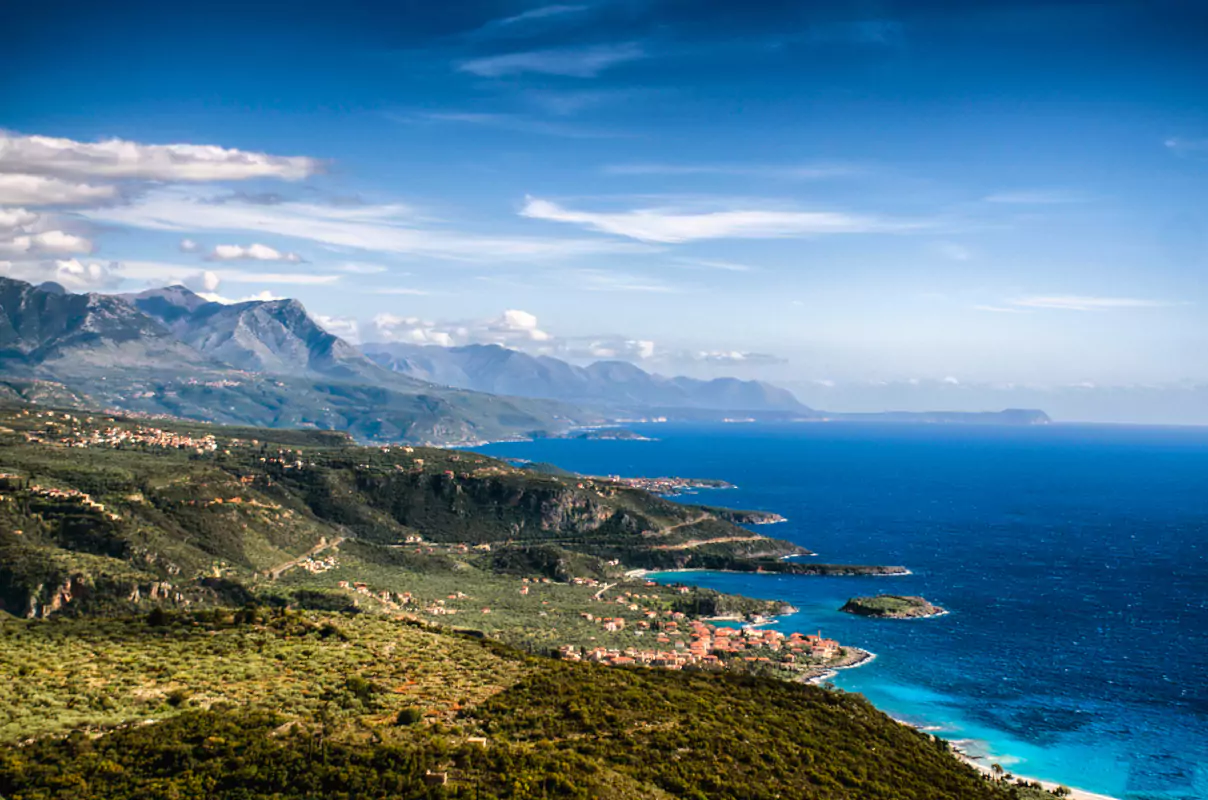Rugged coast of Mani Greece with mountains, sea, and villages like Kardamyli nestled along the shoreline.
